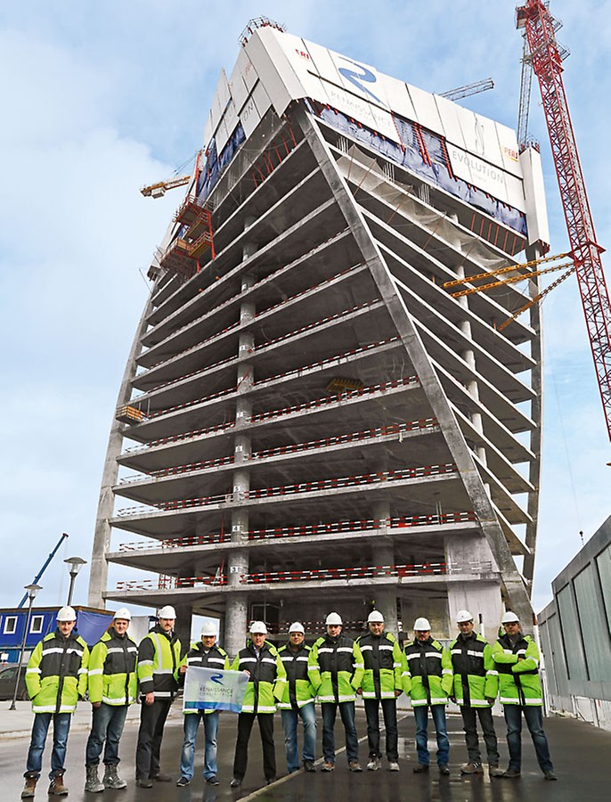 The site management team from Renaissance Construction standing proudly in front of the elegantly twisting Evolution Tower.