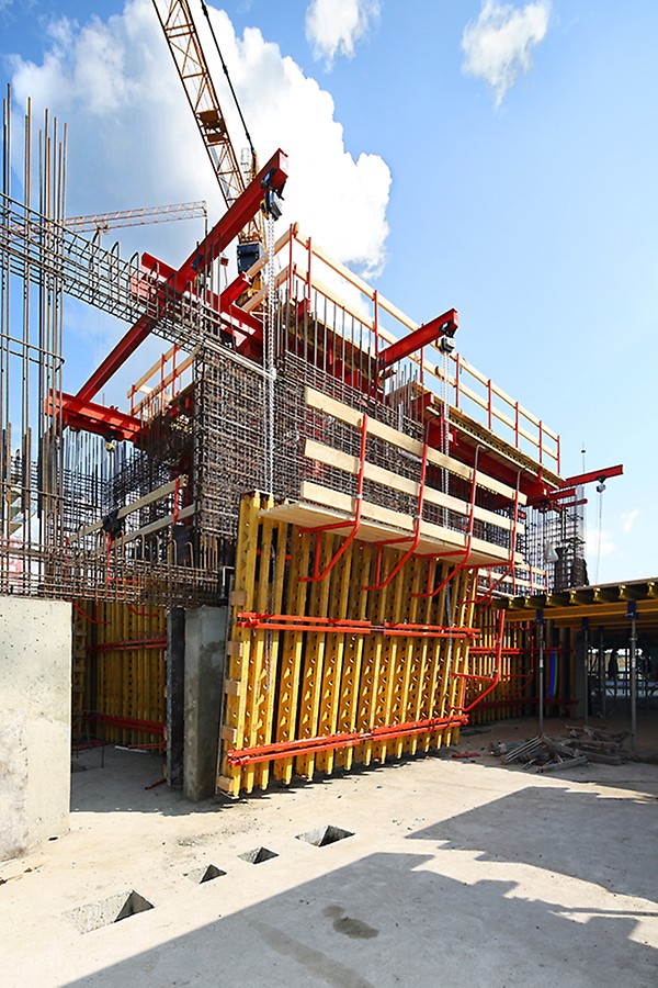 Метод «стены вместе с перекрытием» подразумевает, что первыми бетонируются перекрытия. При этом внутренняя опалубка шахт служит в качестве отторцовки. В свою очередь внешняя опалубка подвешена на цепных талях, что позволяет приподнимать ее для обеспечения доступа в момент бетонирования к участкам перекрытия, примыкающим к ядру.