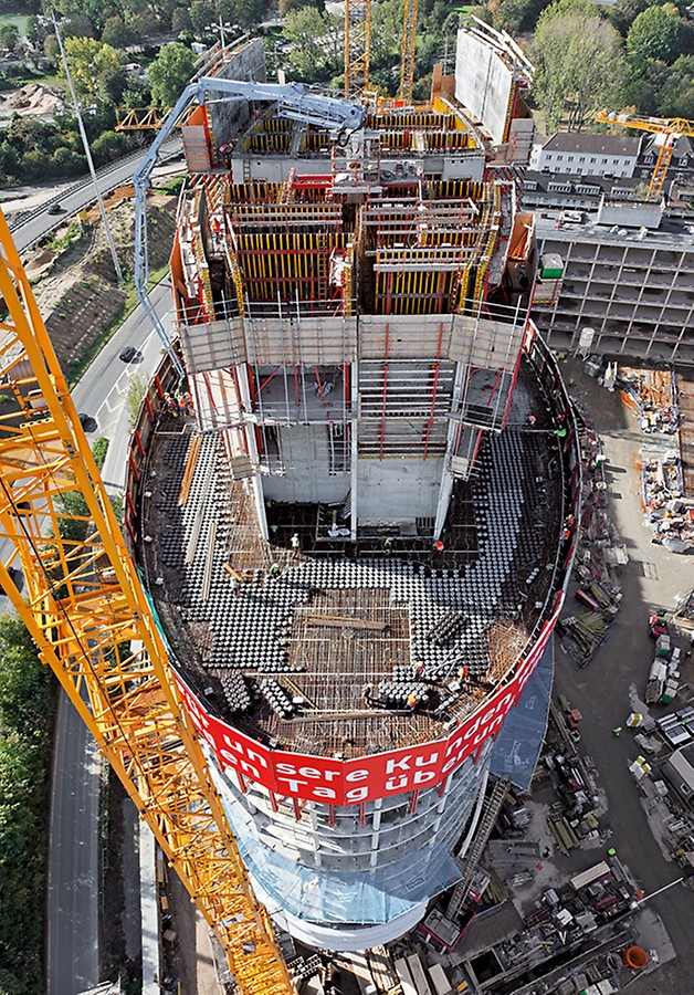Der Stahlbetonkern des elliptisch geformten Büroturms wächst mithilfe der PERI RCS und ACS Selbstklettertechnik nach oben, die RCS Kletterschutzwand sichert die Absturzkanten der nachfolgend zu errichtenden Geschossdecken.