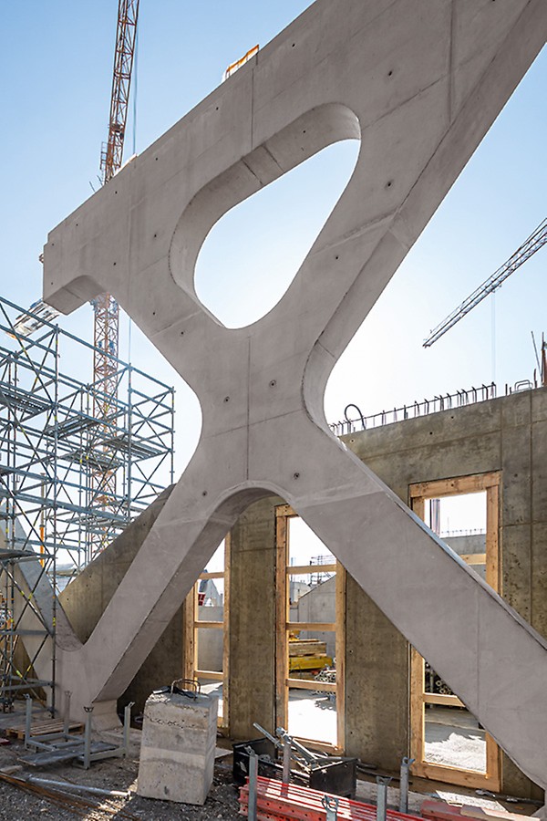 I přes filigránský vzhled vzbuzující dojem otevřeného prostoru podpírá tři horní podlaží 10 m vysoká a 250 m dlouhá vazba příhradových nosníků.