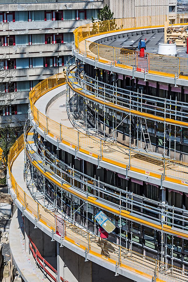 Drei Geschosse legen sich ringförmig und nach oben abgetreppt um den Kuppelbau. PERI UP Fassadengerüste und der PROKIT Seitenschutz sorgten für hohe Sicherheit während der Baumaßnahme.