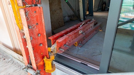 De klimsteigers hangen aan klimschoenen die door een tijdelijke opening zijn bevestigd op de vloer. 