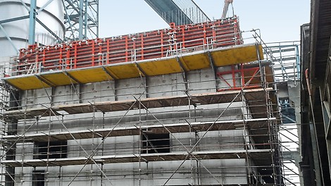Stavba medzizásobníku slinku má obdĺžnikový pôdorys a rástla postupne od základov osadených na širokopriemerových pilótach cez podzemné podlažie až po nadzemné podlažie do výšky 23,85 m, kde je šikmá doska pod dopravníkom umiestnená do šikmých stien
