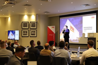 Managing Director of PERI UK, Ian Hayes, speaks to a crowd on stage.