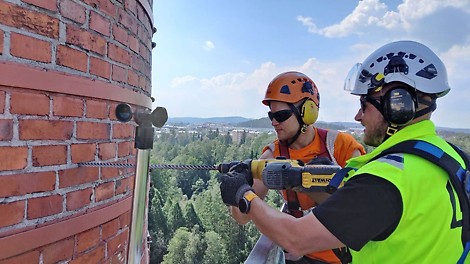 Konsolien kiinnitys piippuun tehtiin telineasentajien ja muurausurakoitsijan ammattimiesten yhteistyönä. 55 senttimetrin paksu piipun tiiliseinä läpipultattiin niin, että muurari kiristi piipun sisäpuolella telineasentajan pulttipistoolilla seinään ampumat pultit.