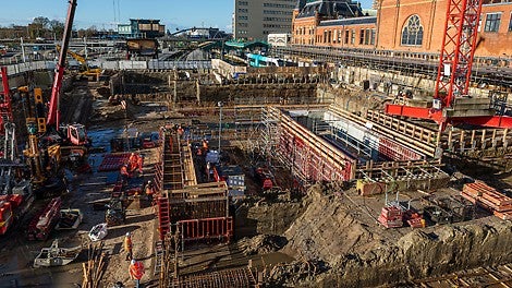Op de achtergrond het historische station van Groningen, op de voorgrond de nieuwbouw van de commerciële ruimte.