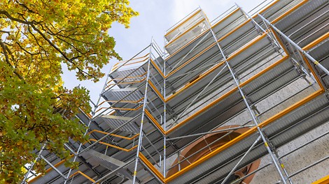 Die Treppe in 67 cm Breite passt sich dank des Gerüstknotens am Easy Stiel nahtlos an das PERI UP Fassadengerüst an. 