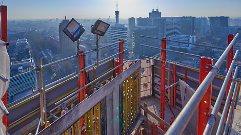 Dankzij het PERI RCS Klimsysteem met geïntegreerd windscherm kan men veilig werken. Uit de wind en op grote hoogte.