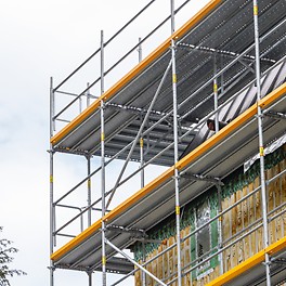 Die obersten Gerüstlagen, insbesondere deren Eckausbildungen, erlauben den sicheren und fachgerechten Rückbau der Kupferfassade und die anschließende Verlängerung des Ortgangs.