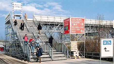 Lösung für eine Messe: Treppe zu einer Fußgängerbrücke über eine mehrspurige Straße mit getrennten Bereichen für den Auf- und Abgang.