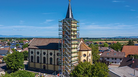 Der Turm der Kirche St. Stephan des Hartheimer Ortsteils Bremgarten ist zur Fassadensanierung und für Putzarbeiten derzeit bis zur Traufhöhe in über 25 m Höhe mit PERI UP Easy in Rahmenbauweise eingerüstet.