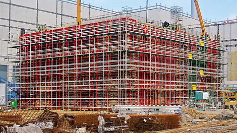 Pentru desfășurarea în siguranță a operațiunilor de cofrare, armare și betonare a pereților cu înălțime de 9.90 m, s-a utilizat schela de lucru PERI UP Rosett.