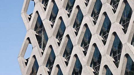 With his design, Polish architect Stefan Kurylowicz has created a striking building with a concrete and glass façade in Warsaw&#039;s city center. The 70-meter-high Prosta Tower is distinguished by its glass front and a diamond-shaped reinforced concrete structure in front, featuring a perfectly exposed concrete finish. The delicate concrete façade envelops the exterior glazing like a net and serves as a load-bearing component.