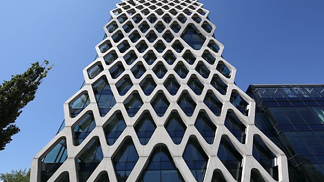 A filigree reinforced concrete net covering the glass facade of the Prosta Tower in Warsaw.