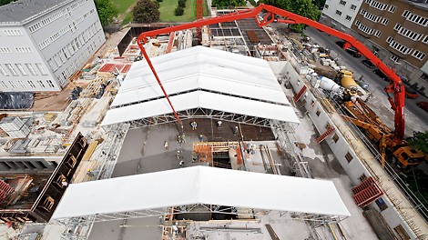 During shell construction, the PERI UP weather-protection roof offers temporary protection against rain, snow or heat. The elements can be moved by hand. In the motor-operated version, the individual segments of roof sheeting can be easily coiled up or uncoiled; a heated version reduces the snow load in winter.