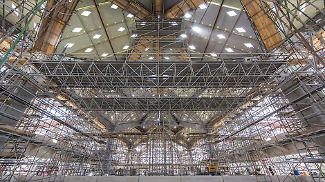 PERI UP Flex Arbeitsplattform LGS 150 mit 25 m Spannweite Verfahrbare Plattformen mit 25 m Spannweite bieten sichere Arbeitsflächen für verschiedene Tätigkeiten an der Untersicht einer Bahnhofüberdachung.