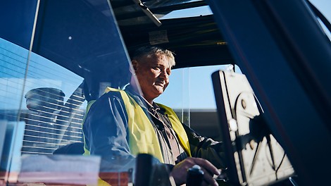 Neue Herausforderungen The picture shows a satisfied PERI employee driving through the factory.