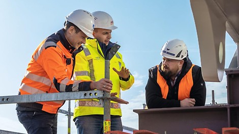 PERI Deutschland Fachberatung Drei Männer auf der Baustelle unterhalten sich