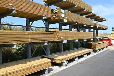 A photograph was taken of softwood plywood panels stacked outside on shelving in a yard.