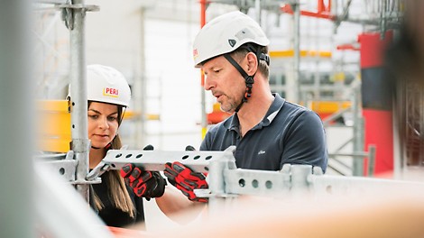 Innovative Lösungen Anblick auf das PERI UP Gerüstsystem, an welchem gerade eine Produktvorführung stattfindet.