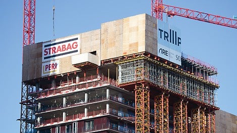 The VST Heavy-Duty Shoring Towers are secured to the building by retaining structures. The surface-mounted distribution platform serves to accommodate the PERI UP scaffolding.