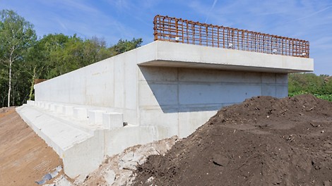 Gestort landhoofd vanaf de weg gezien. De liggers aan de landhoofden en middenpijler worden gemonteerd tijdens een buitendienststelling van de weg.