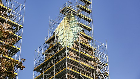 Rusztowanie przy wieżach kościoła z dostępem do archiwalnych informacji zawartych w kopułkach pod krzyżem.