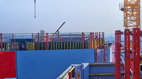 Het geïntegreerde windscherm in grijs, naar wens van de klant. Verder zie je de VARIO buitenbekisting. De steigerbuisleuningen zijn strak geplaatst als valbeveiliging.
