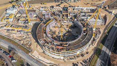 Luftansicht von oben auf die Baustelle in Sigmaringen. Zu sehen sind ein runder Gebäudekomplex und ein großes (rechteckiges) Gebäude während des Baus.