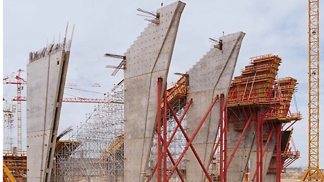 最高18.25 mのタワーPD8 は、傾斜した連結梁の型枠を支えます。<br/>壁の厚さが上方に向かって増すため、VARIO GT24大型壁型枠は、最終のコンクリート打設サイクルで外に傾いています。<br/>