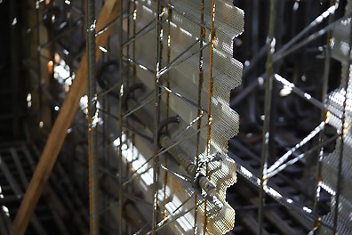 Metal cage with bars and wires inside, with metal mesh stop ends seen on a construction site.