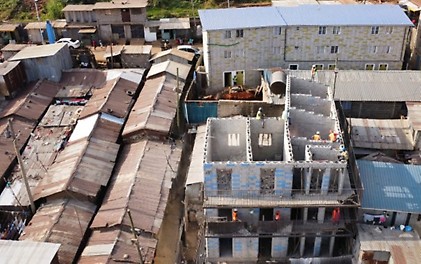 TwistBlocks stand for a reimagined way of building. TwistBlock social housing under construction and an already completed residential block in the Kibera slum, Nairobi.