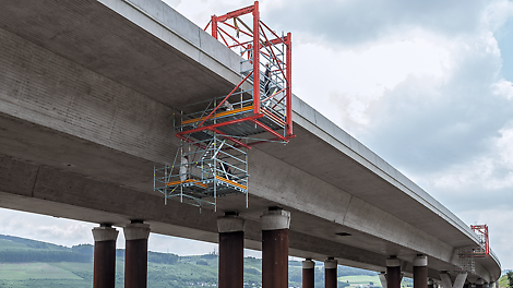 В верхней части подвесной конструкции используется базовая рама, нагруженная балластом. Для перемещения лесов вдоль моста рама оснащается колесами. Устройство такой системы позволяет проводить работы без остановки движения.