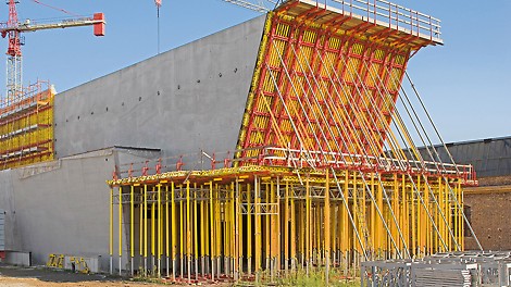The concrete loads resulting from construction of the reverse-inclined front wall could be safely transferred to the ground via a frame construction unit and MULTIPROP towers.