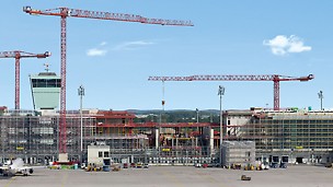 Satelitski terminal zračne luke München - 600 m dugački, novi satelitski terminal zračne luke München nalazi se usred piste, okružuje toranj i temelji se na postojećoj površini za sortiranje prtljage. Gradnja uz tekući rad zračne luke bio je enorman izazov za sve sudionike projekta. 