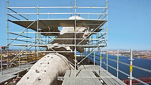 Cristo Rei Monument, Lissabon, Portugal - Auf den großzügigen und geometrisch angepassten Arbeitsplattformen der PERI UP Rosett Einrüstung am Kopf der Statue konnte in über 100 m Höhe sicher gearbeitet werden.