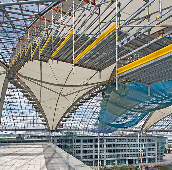 Zastřešení na mnichovském letišti: Konstrukce z lešení PERI UP je upevněna na kosočtvercových střešních nosnících upevněna speciálně vyvinutým zařízením.