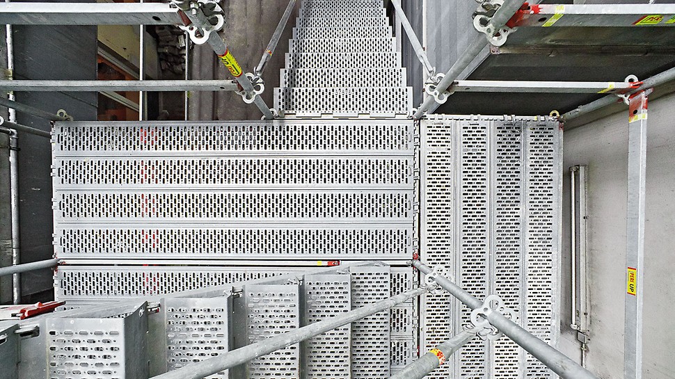 Ocelové schodiště PERI UP 100 / 125: Perforovaný povrch stupňů je velmi bezpečný proti skluzu, i v případě pohybu v botách znečištěných olejem.