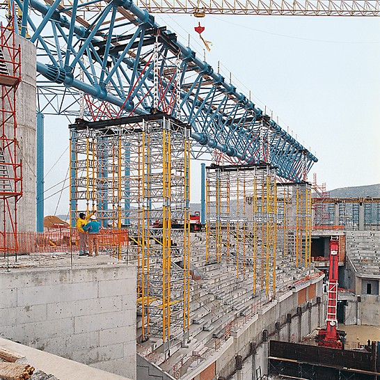 Heavy athletics stadium, Athens, Greece - After fixing the 72 m long steel truss, three shoring towers were lifted by crane to the next point of use in the form of a cost-effective moving unit.