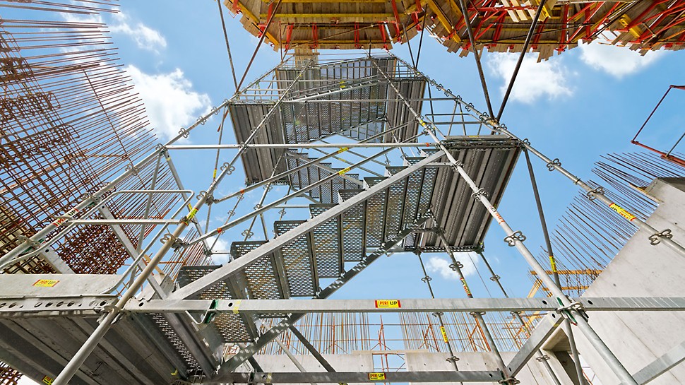 Bezpiecznie i wygodnie: schody przeciwbieżne PERI UP Rosett Flex Steel o szerokości 1,00 m i oddzielnych spocznikach.
