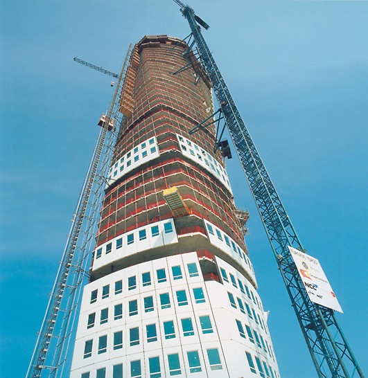 Turning Torso, Malmo, Szwecja
Zaprojektowany jako wieżowiec mieszkalny, projekt składa się z 54 pięter i osiąga zawrotną wysokość 190 metrów. Projekt hiszpańskiego architekta Santiago Calatravy opiera się na rzeźbie inspirowanej ruchem obrotowym ludzkiego ciała. Pomosty samoczynnego wspinania wznosiły jednostki formujące okrągły trzon wieżowca z piętra na piętro. Dzięki temu, że rozściełacz mieszanki betonowej został umieszczony w środku konstrukcji, wznosił się razem z pomostami wspinania.