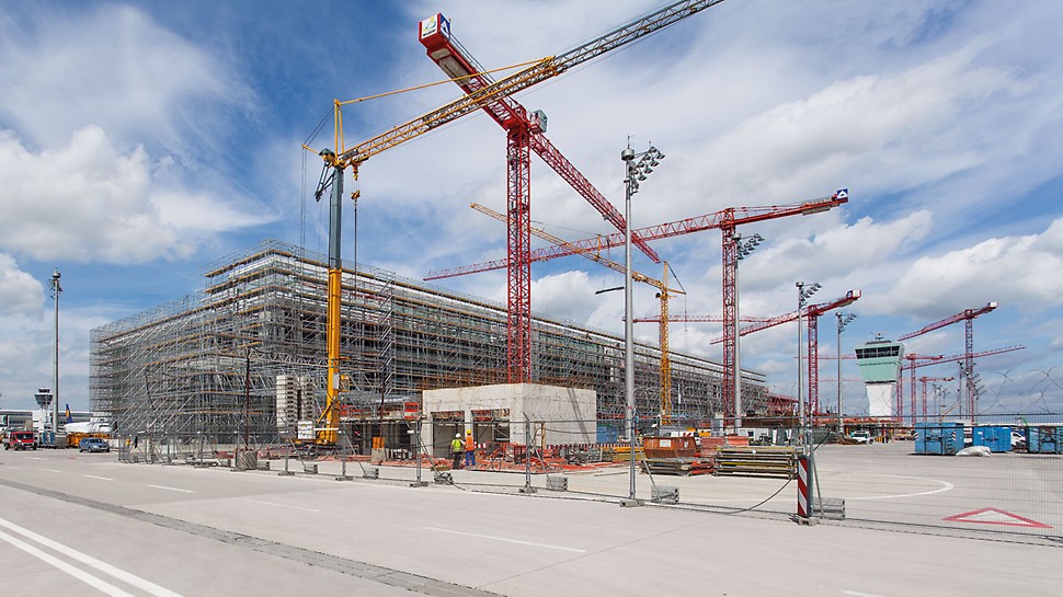Satelitski terminal zračne luke München, Njemačka - PERI rješenje za ovo veliko gradilište jest sveobuhvatna kompletna usluga: raspoloživost velikih količina materijala, fleksibilan inženjering, logistika po mjeri te usluge koje prate gradilišne tijekove uz podršku PERI voditelja projekta. Čitav ovaj paket donosi izvođačima višak vrijednosti - i građevinskom poduzeću i poduzeću za montažu skele. 