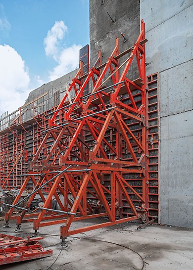 Ściany jednostronne w systemie kozłów oporowych SB. Scalone jednostki przestawiane są wraz z deskowaniem na kolejny etap betonowania. 
