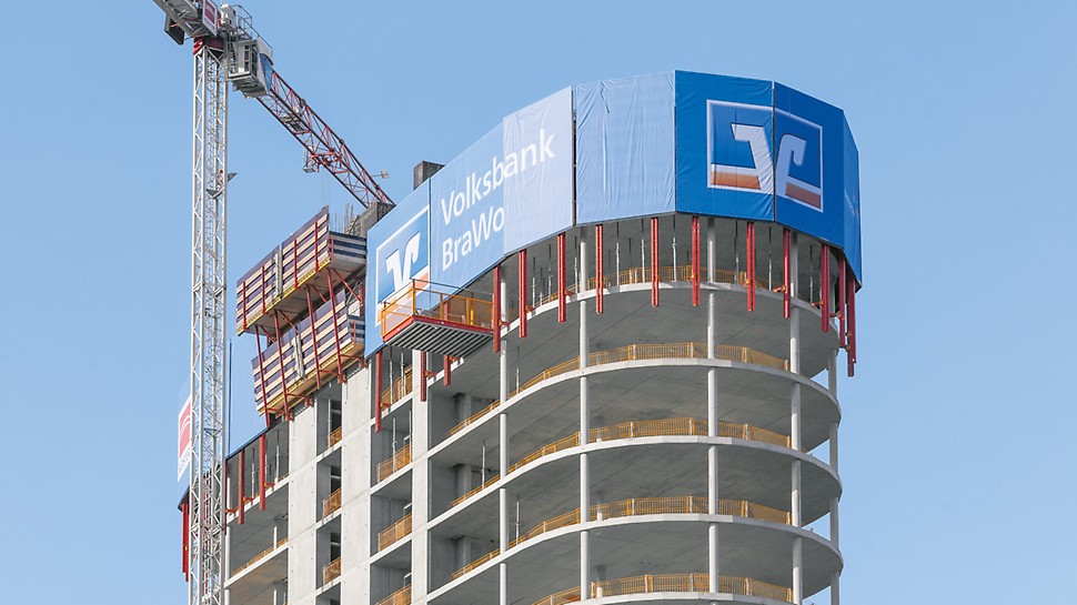 Die obersten Stockwerke des BraWoPark Business Centers II in Braunschweig, bei dem die PERI RCS Kletterschutzwand in den zwei obersten Etagen für Werbezwecke eingesetzt wird. 