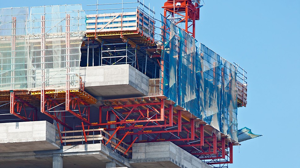Vyložené příhradové konstrukce VARIOKIT z pronajímatelného materiálu odvádějí vysoké zatížení čerstvý betonem z masivních balkonů s tloušťkou 28 cm a výškou parapetu 1,30 m.