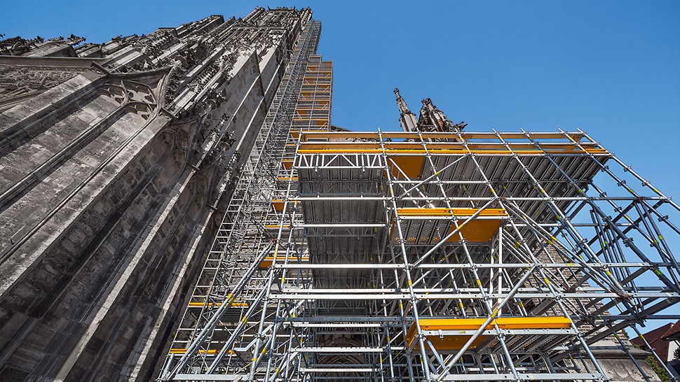 PERI UP schmiegt sich für die umfangreichen Sanierungsarbeiten bis auf 71 m Höhe an das Ulmer Münster an. Eine Zwischenplattform in 7 m Höhe dient als Lagerungsmöglichkeit für die neuen Steine.