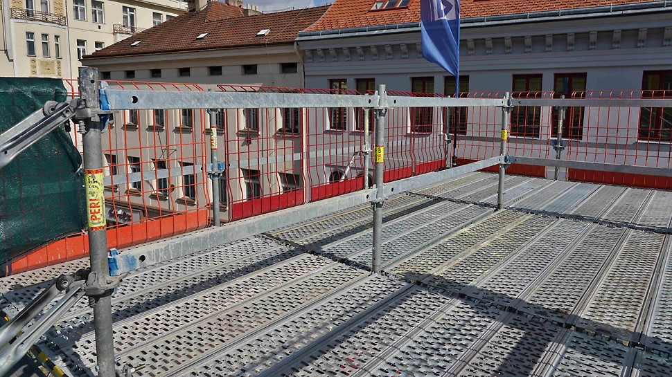Horní podesta schodiště PERI UP s ochrannými mřížemi proti pádu z výšky PROKIT. Zajištění bezpečného pohybu po mostovce v Den otevření stavby.