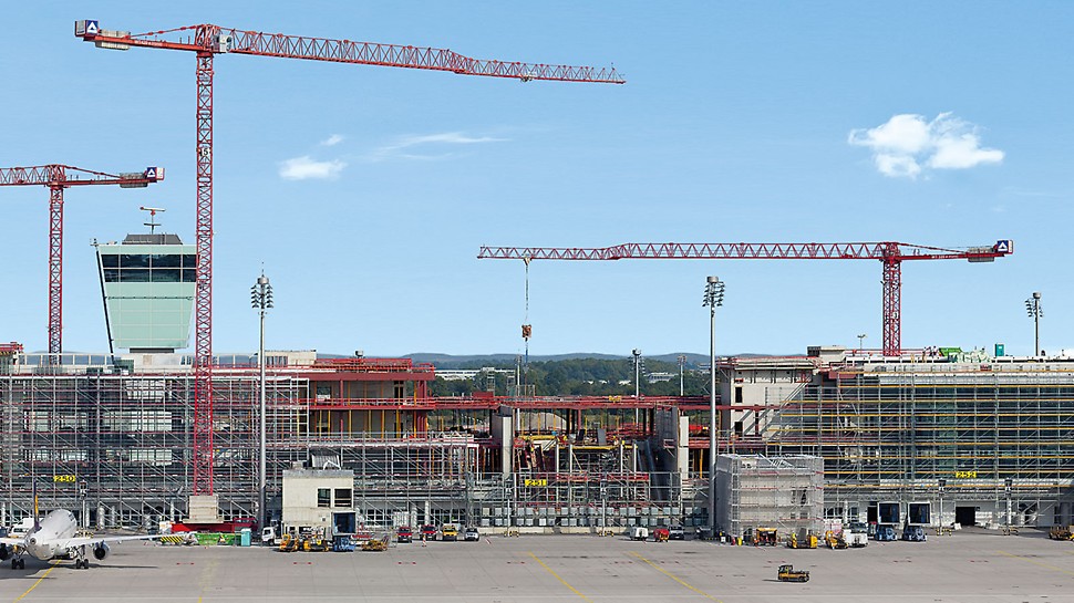 Satellitenterminal Flughafen München, Deutschland - Der 600 m lange, neue Satellitenterminal am Flughafen München befindet sich inmitten des Flugfelds, es umschließt den Vorfeldtower und gründet auf der vorhandenen Gepäcksortieranlage. Das Bauen im laufenden Betrieb ist eine enorme Herausforderung für alle Projektbeteiligten.