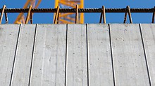 Pozoruhodné betonové plochy s požadovaným otiskem prken byly vytvořeny díky půlkruhovému vyfrézování třívrstvých bednicích desek provedenému před jejich vsazením do rámů bednění MAXIMO Struktur.