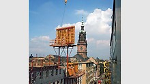 1973 erhöht das weltweit erste Klettergerüst die Sicherheit und das Arbeitstempo auf der Baustelle. Die kühne Konstruktion rationalisiert das Bauen hoher Gebäude erheblich, denn Schalung und Gerüst lassen sich in einem Kranhub umsetzen.
